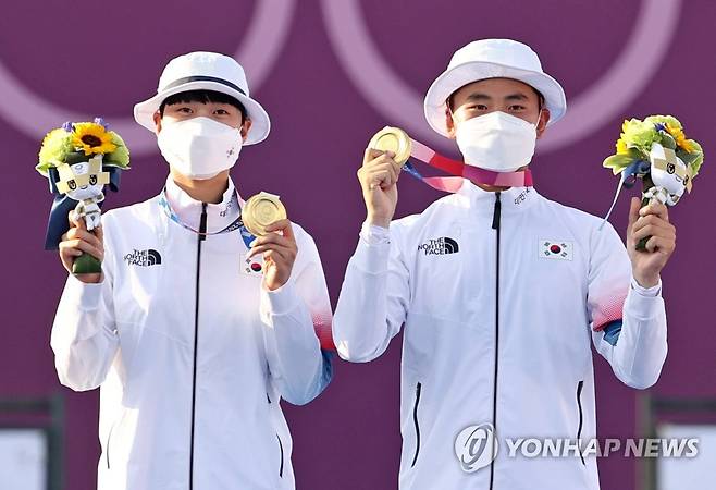 [올림픽] 김제덕-안산, 양궁 혼성 금메달 (도쿄=연합뉴스) 류영석 기자 = 양궁 국가대표 김제덕과 안산이 24일 일본 도쿄 유메노시마 공원 양궁장에서 열린 도쿄올림픽 혼성 결승전에서 금메달을 획득한 후 메달을 보이고 있다. 2021.7.24 ondol@yna.co.kr