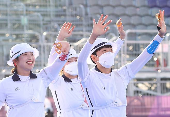 25일 일본 도쿄 유메노시마 공원 양궁장에서 열린 양궁 여자단체전 결승전에서 금메달을 획득한 장민희, 강채영, 안산이 관람석을 향해 손을 흔들고 있다./연합뉴스