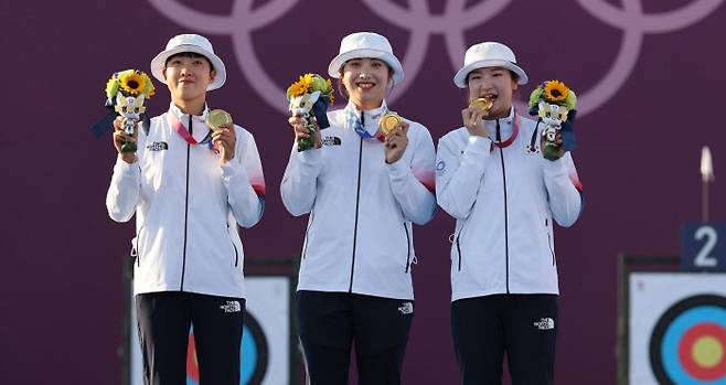 안산, 장민희, 강채영(왼쪽부터) 등이 25일 일본 도쿄 유메노시마공원 양궁장에서 열린 2020 도쿄 올림픽 양궁 여자 단체전에서 금메달을 획득한 후 시상대에서 기념촬영을 하고 있다.    올림픽사진공동취재단