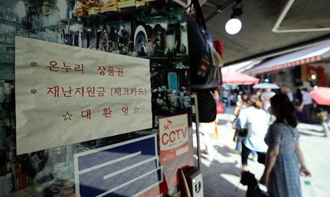 지난 24일 서울 중구 남대문 시장장의 한 매장에 재난지원금 사용 가능 안내문. 연합뉴스