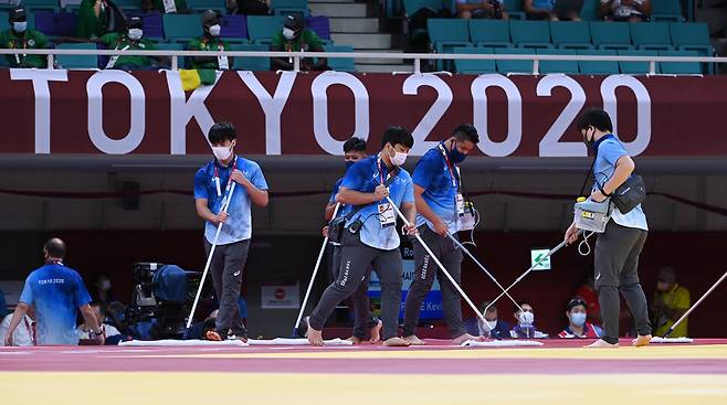 25일 2020 도쿄올림픽 유도 경기가 펼쳐진 일본 지요다구 일본부도칸(무도관)에서 조직위 의료 관계자들이 세정액으로 경기 매트를 닦으며 소독하고 있다. 도쿄/올림픽사진공동취재단