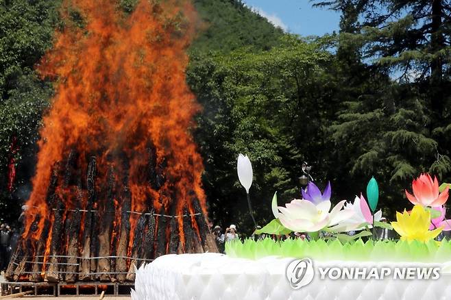 '속히 돌아오소서' (김제=연합뉴스) 나보배 기자 = 26일 전북 김제 금산사 다비장 연화대에서 월주스님의 법구를 태워 유골을 거두는 불교 전통 장례의식인 다비식이 거행되고 있다. 2021.7.26 warm@yna.co.kr