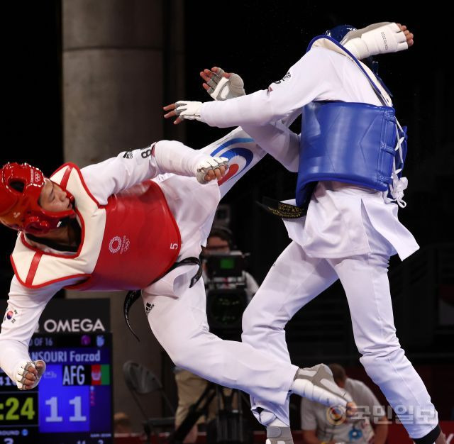 인교돈이 27일 일본 지바 마쿠하리메세 A홀에서 열린 도쿄올림픽 남자 태권도 80㎏ 초과급 16강전에서 3라운드 종료를 24초 남기고 만수리 파르자드(아프가니스탄)의 머리에 돌려차기를 꽂아 넣고 있다. 이 순간 파르자드의 헤드기어가 날아갔다. 지바=김지훈 기자