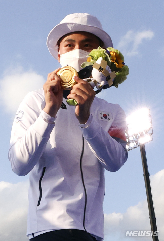 [도쿄(일본)=뉴시스] 최진석 기자 = 대한민국 양궁 대표팀 안산과 김제덕이 24일 오후 일본 도쿄 유메노시마 양궁장에서 열린 2020 도쿄올림픽 양궁 남녀혼성단체전에서 우승을 차지한 뒤 금메달을 들고 기뻐하고 있다. 2021.07.24. myjs@newsis.com