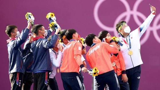 26일 도쿄올림픽 남자 양궁 단체전에서 우승한 김제덕, 김우진, 오진혁이 일본 유메노시마 공원 양궁장 시상대에서 은메달, 동메달 수상자들과 기념촬영을 하고 있다. 연합뉴스