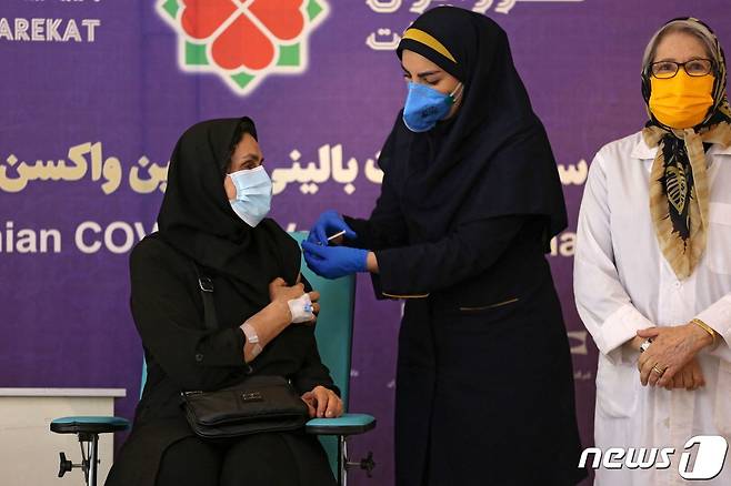 이란 수도 테헤란에서 2021년 3월 15일 의료진에게 이란이 자체 개발한 코로나19 백신을 접종하는 모습.  © AFP=뉴스1