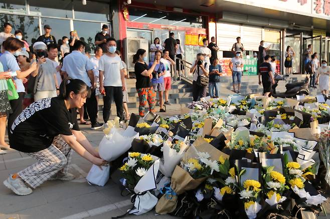 27일 중국 허난성 정저우시의 지하철 5호선 샤커우루역 앞에 시민들이 놓은 꽃이 쌓여 있다. 지난 20일 정저우에 내린 폭우로 지하철에 물이 들어차면서 퇴근길 승객 14명이 숨졌다./EPA 연합뉴스