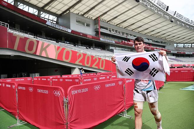 28일 일본 도쿄스타디움에서 열린 도쿄올림픽 7인제 럭비 대한민국 대 일본 11~12위 결정전 경기를 마친 후 안드레진이 태극기를 펼친 채 경기장을 나서고 있다.