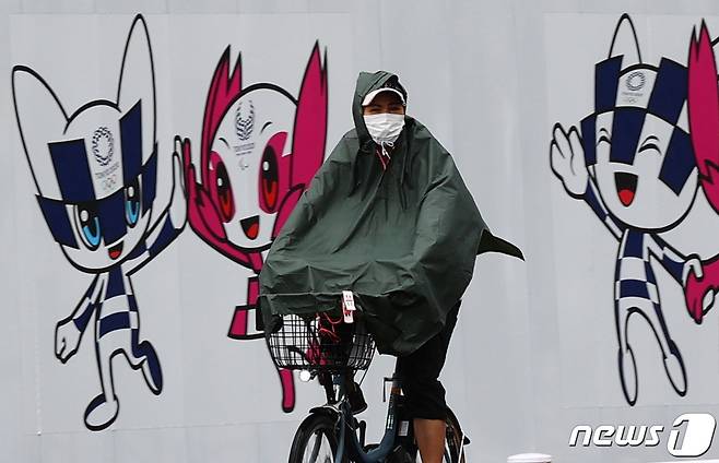 일본 도쿄에서 27일(현지시간) 우의를 입은 한 남성이 자전거를 타고 가고있다. © 로이터=뉴스1