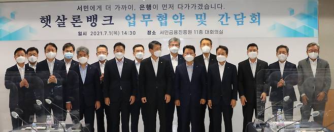 은성수 금융위원장과 이계문 서민금융진흥원장, 김광수 은행연합회장 등 13개 시중 은행장들이 1일 서울시 중구 서민금융진흥원에서 열린 햇살론뱅크 업무협약식에서 협약서에 서명한 뒤 기념촬영을 하고 있다./연합뉴스