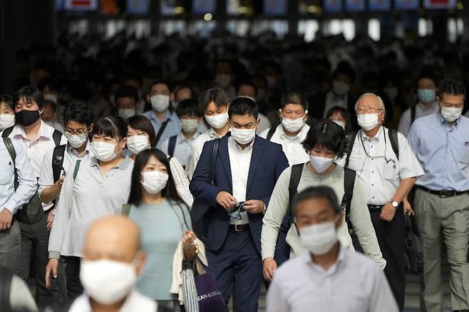 출근 시간 일본 도쿄 시나가와역에서 마스크를 쓴 시민들이 통로를 걸어가고 있다. AP/뉴시스