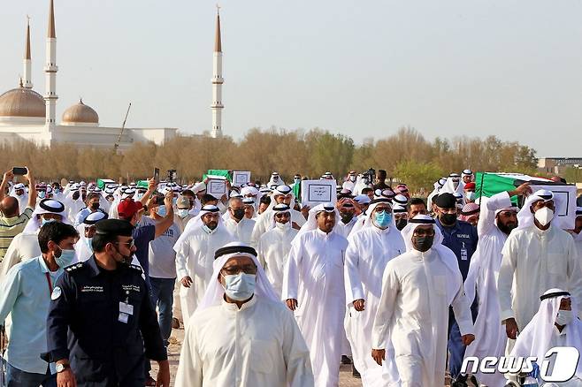 쿠웨이트 한 공동묘지에서 포로 10명의 시신이 DNA 검사로 확인된 뒤 조문객들이 늘고 있다. 2021년 7월 14일 조문객들이 마스크를 쓰고 방문하는 모습. © AFP=뉴스1