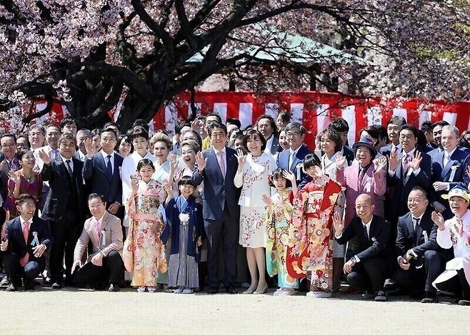 지난 2019년 4월13일 아베 신조 전 일본 총리가 도쿄 신주쿠교엔에서 열린 ‘벚꽃을 보는 모임’에 참석해 참석자들과 기념사진을 찍는 모습. 일본 내각총리관저