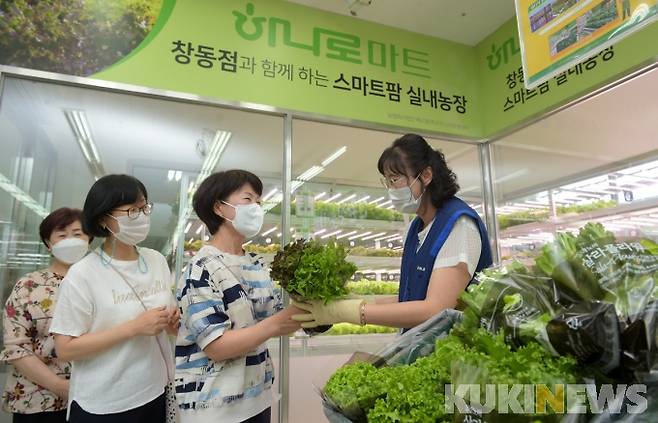 30일 농협유통 하나로마트 창동점(서울 도봉구 소재)에 선보인 ‘스마트 팜’에서 첫 수확한 채소를 NH농협은행 우수고객에게 증정하는 행사를 갖고 있다.