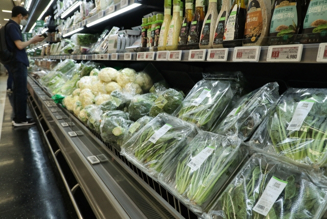 폭염으로 시금치 등 농식품 가격이 급등하고 있다. 서울 한 유통마트에서 시민들이 매대에 채소를 살펴보고 있다 [사진 = 연합뉴스]