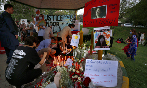25일(현지시간) 파키스탄 이슬라마바드에서 열린 누아르를 비롯한 가정폭력 피해자들을 추모하는 촛불집회 도중 최근 참혹하게 살해된 누아르 무카담의 사진 옆에 촛불과 꽃을 놓고 있다. AP연합뉴스