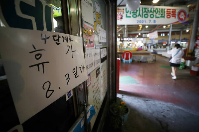 지난달 28일 서울 인왕시장 내 한 가게에 ‘4단계로 휴가’라고 적힌 안내문이 붙어 있다. 연합뉴스