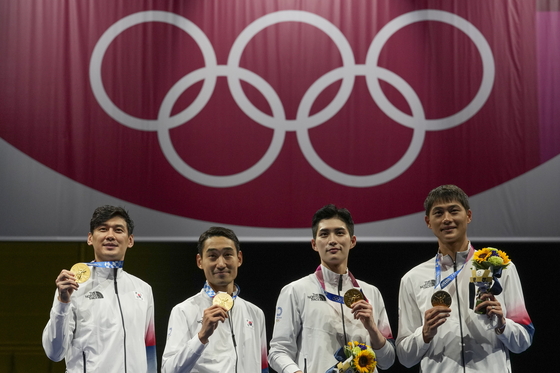 The Korean men's sabre team, from left, Gu Bon-gil, Kim Jung-hwan, Kim Jun-ho and Oh Sang-uk celebrate on the podium at the 2020 Summer Olympics on July 28 in Chiba, Japan. [AP/YONHAP]