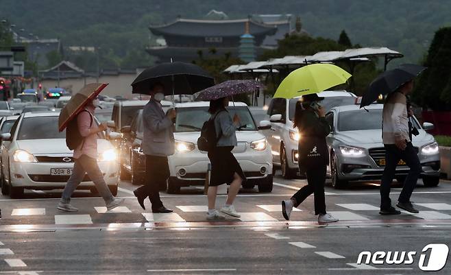 비가 내리는 서울 종로구 광화문 네거리에서 비로 인해 시야가 어두워지자 차량들이 전조등을 켜고 달리고 있다. /사진=뉴스1