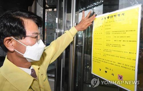 1일 김한근 강릉시장이 코로나19 방역수칙을 위반한 강릉의 한 호텔에 영업정지 명령서를 부착하고 있다. [촬영 이해용]