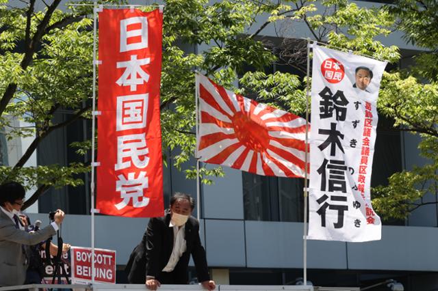 대한민국 올림픽 선수단 본진이 도쿄로 입성하는 지난달 19일 도쿄올림픽 대한민국 올림픽 선수촌 앞에서 일본 극우단체 회원들이 욱일기를 세우고 시위하고 있다. 도쿄=뉴스1