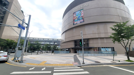 The street outside Busan's Shinsegae Centum City Mall stands empty on Tuesday after an employee tested positive on Monday. The store where the employee worked temporarily closed on Tuesday. The mall is connected to Shinsegae Department Store, where 11 cases were reported after a worker at its Chanel store tested positive on July 28. [YONHAP]