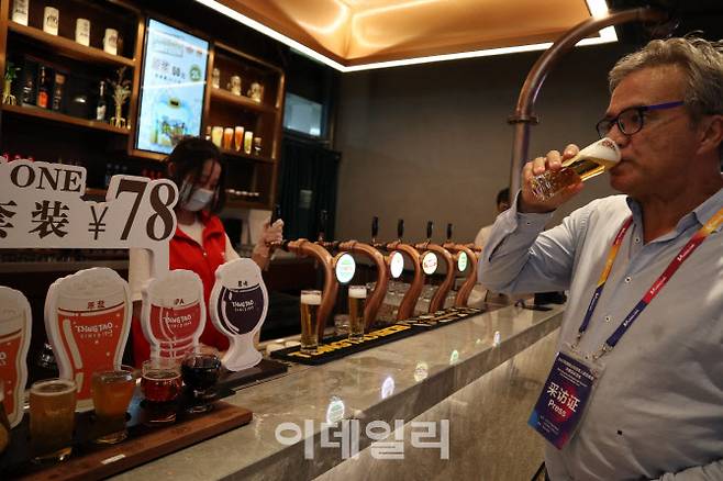 칭다오맥주 공장에서 막 생산된 ‘원장맥주’를 한 외신기자가 시음하고 있다.