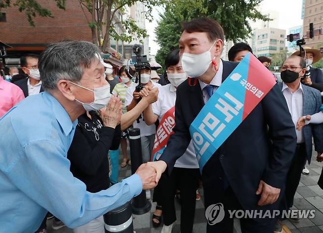 지지자들과 악수하는 윤석열 대선 예비후보 (서울=연합뉴스) 국민의힘 윤석열 대선 예비후보가 3일 오후 서울 은평구 응암역 앞에서 국민의힘 당원 가입을 독려하는 홍보 활동을 위해 이동하며 지지자들과 악수하고 있다. 2021.8.3 [국회사진기자단] toadboy@yna.co.kr