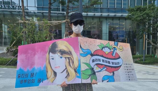 6일 오후 4시쯤 서울 강남구 역삼동에서 한 시민이 '쥴리 벽화' 팻말을 들고 서 있다. /윤예원 기자