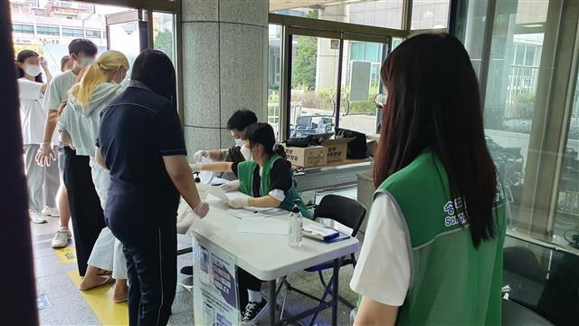 서울 송파구 송파구민회관에 마련된 코로나19 예방접종센터에서 자원봉사자들이 방문자들에게 동선을 안내하고 있다.송파구 제공