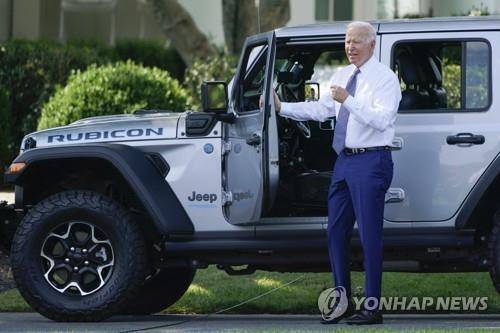 조 바이든 미국 대통령이 5일(현지시간) 백악관 사우스론에서 열린 친환경차 계획 발표 현장에서 지프 랭글러 리미티드 루비콘 4xE 옆에서 포즈를 취하고 있다. [AP=연합뉴스]