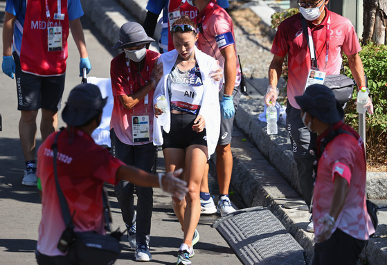 An Seul-ki of Korea is assisted at the finishing line of the women's marathon race at Sapporo Odori Park, Sapporo, Japan on Saturday. [REUTERS/YONHAP]