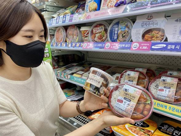 편의점 세븐일레븐이 이달부터 새롭게 선보인 2000원대 ‘이딸라 도시락’을 모델이 들어보이고 있다.(사진=코리아세븐)