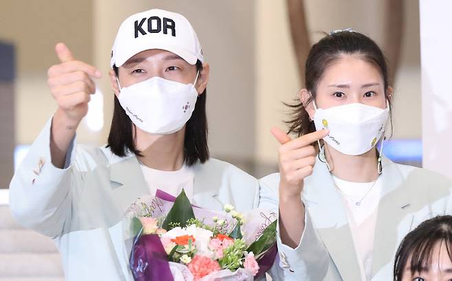 김연경(왼쪽)과 김수지가 9일 오후 인천국제공항을 통해 귀국하며 환영나온 팬들을 향해 ‘손가락 하트’를 보이며 고마움을 전하고 있다. (사진=연합뉴스)