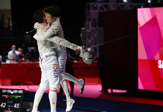 Korean sabrist Oh Sang-uk, left and Gu Bon-gil celebrate the men’s sabre team's win against Germany in the semifinals on Wednesday at the Makuhari Messe Hall in Chiba, Japan. [YONHAP]