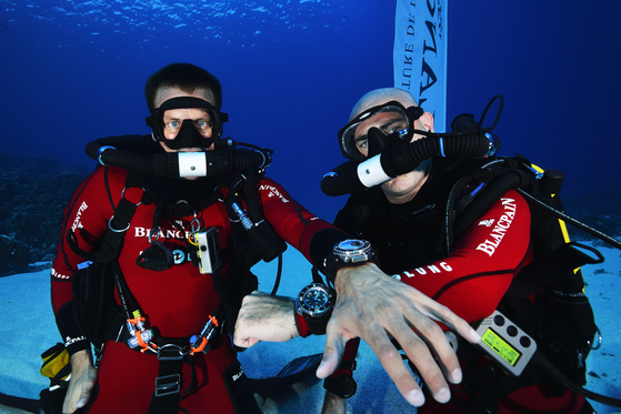 Marc A. Hayek, right, president and CEO of Switzerland-based luxury watch brand Blancpain, poses for a photo with the Fifty Fathoms watch during an ocean expedition. [BLANCPAIN]
