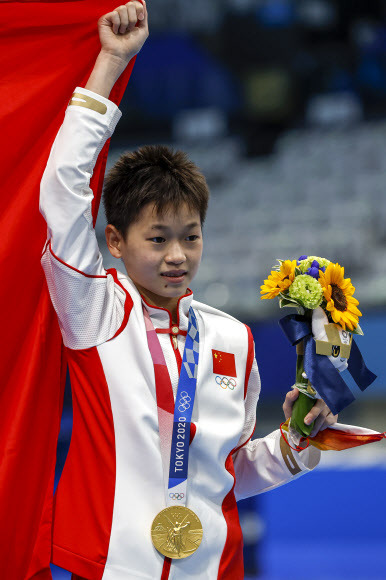 취안홍찬(중국)이 지난 5일 일본 도쿄 아쿠아틱스 센터에서 열린 2020 도쿄올림픽 다이빙 여자 플랫폼 10m 결선 결과 우승을 확정지어 중국의 4개 대회 연속 여자부 4종목 석권을 마무리한 뒤 오성홍기를 들어 보이고 있다.로이터 자료사진 연합뉴스