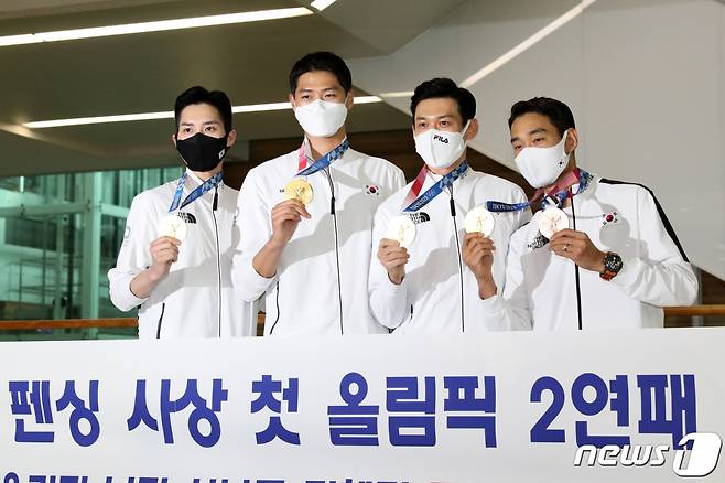 (인천공항=뉴스1) 이승배 기자 = 2020 도쿄 올림픽 남자 펜싱 사브르 국가대표 (왼쪽부터)김준호, 오상욱, 구본길, 김정환이 29일 오후 인천국제공항을 통해 귀국해 포토타임을 갖고 있다.  남자 펜싱 사브르 단체는 도쿄올림픽에서 금메달을 획득해 한국 펜싱 사상 첫 올림픽 2연패를 달성했다. 2021.7.29/뉴스1