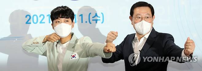 광주서 '활시위 세리머니' 재연하는 안산 (광주=연합뉴스) 정회성 기자 = 11일 광주시청 소회의실에서 2020 도쿄올림픽 양궁 3관왕에 오른 안산(왼쪽) 선수와 이용섭 광주시장이 여자 양궁 단체전 금메달 수상 당시 '활시위 세리머니'를 재연하고 있다. 안산은 이날 광주시 명예홍보대사에 위촉됐다. 2021.8.11 hs@yna.co.kr