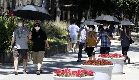 폭염이 계속된 5일 오후 울산 동구 대왕암공원을 찾은 시민들이 양산을 쓴 채 걷고 있다. [뉴스1]