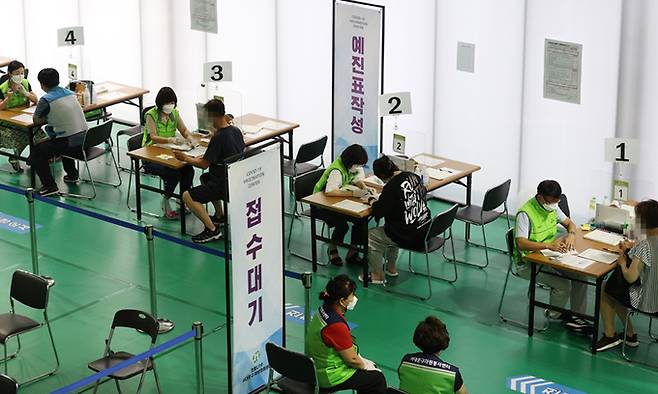 13일 서울 서대문구 북아현문화체육센터에 마련된 예방접종센터에서 시민들이 예진표를 작성하고 있다. 연합뉴스