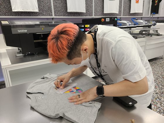 '나이키 서울' 매장 직원이 즉석에서 무늬없는 티셔츠에 스티커를 부착하는 모습. 이소아 기자