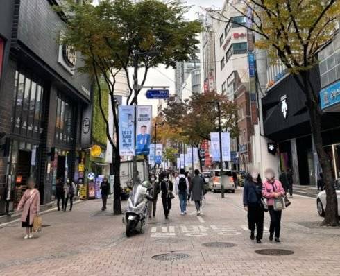 위의 사진과 비슷한 각도에서 찍은 2020년 11월의 명동 입구 모습. 빌딩에 가려 명동성당은 안 보이고 쇼핑백을 들거나 핸드백을 멘 행인으로 북적거리고 있다. 김홍준 기자