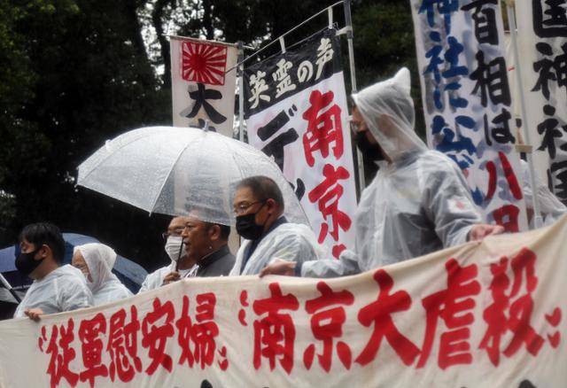 일본의 패전 76주년인 15일 일본 도쿄도(東京都) 지요다(千代田)구 소재 야스쿠니신사(靖國神社)에 비가 내리는 가운데 우익 성향으로 추정되는 이들이 일본군 위안부 문제와 난징(南京)대학살 관련 기술을 교과서에서 삭제하라고 요구하는 현수막을 들고 있다. 도쿄=연합뉴스