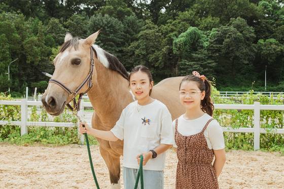 강지민(왼쪽) 학생기자와 유지민 학생모델이 경기도 과천시에 있는 렛츠런파크를 찾아 말 산업 관련 직업들을 알아봤다. 사진=지다영(오픈스튜디오)