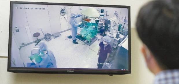 수술실 폐쇄회로TV(CCTV) 설치 의무화 방안을 담은 의료법 개정안이 23일 국회 보건복지위원회 전체회의를 통과했다. 인천 부평힘찬병원 관계자가 수술실 내 CCTV 카메라로 수술 상황을 녹화하고 있다.  한경DB