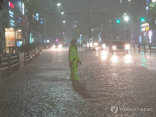 침수된 도로 교통정리 하는 경찰 (부산=연합뉴스) 손형주 기자 = 태풍 오마이스가 경남 고성에 상륙한 24일 밤 부산 서면 삼정 타워 앞 도로가 침수돼 경찰이 교통정리를 하고 있다. 2021.8.24 [부산경찰청 제공. 재판매 및 DB 금지] handbrother@yna.co.kr
