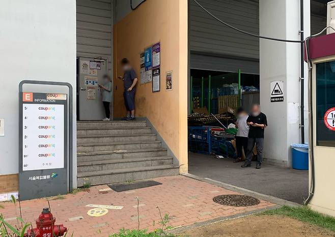 쿠팡서울물류센터 입구에서 담배를 피우는 사원들. /김은영 기자