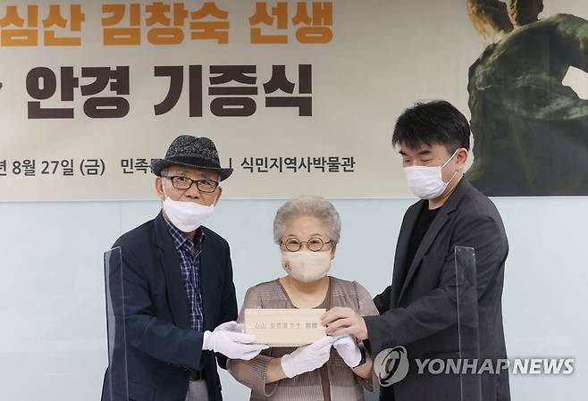 심산 김창숙 선생 안경 기증식 (서울=연합뉴스) 한종찬 기자 = 27일 오후 서울 용산구 식민지역사박물관에서 열린 심산 김창숙 선생 안경 기증식에서 손녀 김주 여사(가운데)가 안경을 들고 기념촬영을 하고 있다. 2021.8.27 saba@yna.co.kr