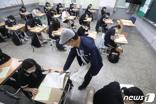 2022학년도 대학수학능력시험 9월 모의평가가 실시된 1일 오전 대구혜화여고 3학년 교실에서 감독관이 수험생들에게 시험지를 나눠주고 있다. 수능을 앞두고 마지막으로 치러지는 이번 모의평가는 한국교육과정평가원 주관으로 전국 2138개 고등학교와 431개 지정학원에서 동시에 실시된다. 2021.9.1/뉴스1 © News1 공정식 기자